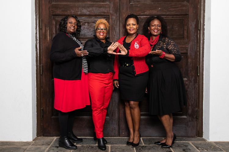 DST members wearing red and throwing up the hand sign, which is two hands together in a triangle shape