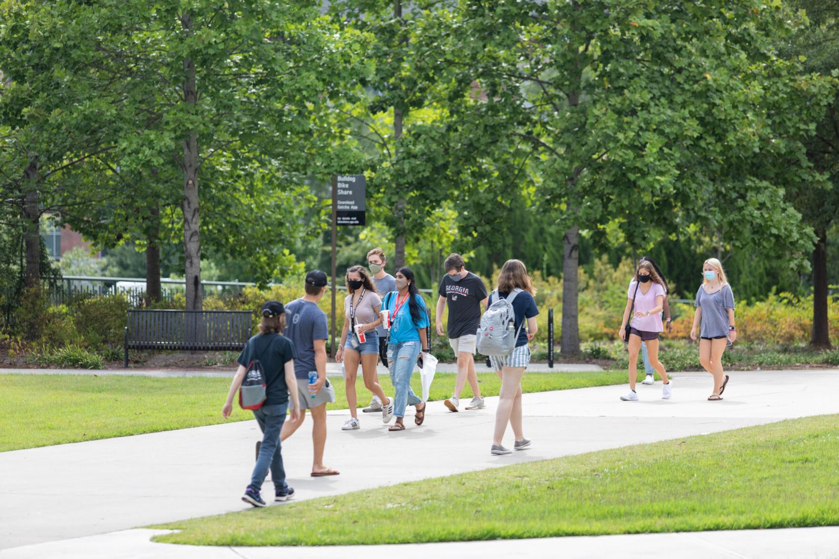 Students walking on campus with masks