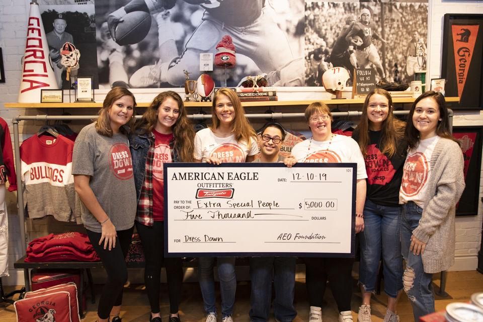 Group of people in store holding large check