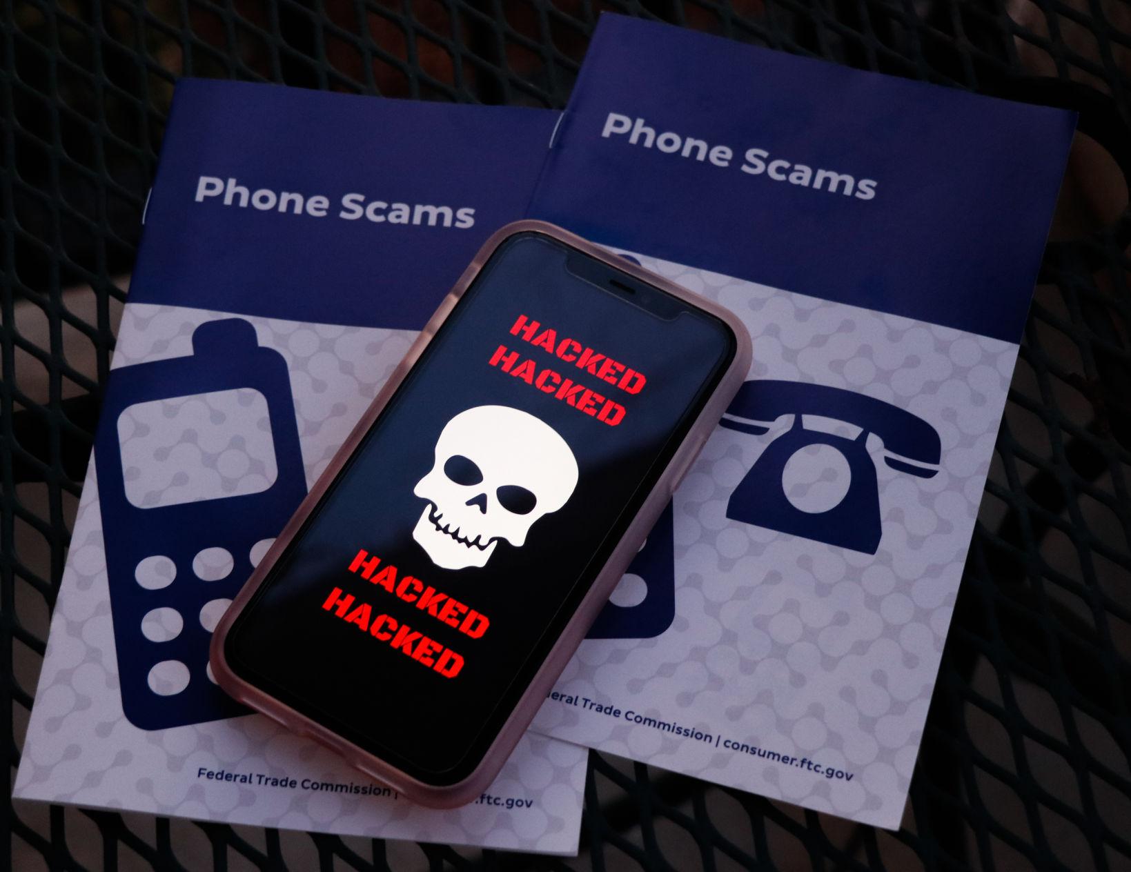 Graphic of a phone that reads 'Hacked' on top of scamming brochures
